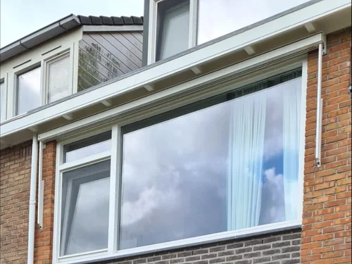 Screen gemonteerd boven een grote raampartij door Hermann Zonwering